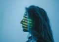 Silhouette of a woman with binary code projected on her face in a digital concept setting.